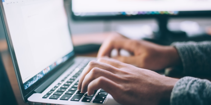 Close-up of hands typing on a laptop keyboard, showcasing the integration of 'AI in Financial Marketing'.